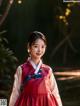 A woman in a red and white hanbok poses for a picture.