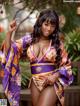 A woman in a purple and orange kimono posing for a picture.