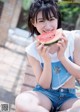 A young woman eating a slice of watermelon.