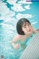 A woman in a blue bikini in a swimming pool.