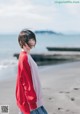 A woman standing on a beach next to the ocean.