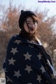 A woman wrapped in a blanket with stars on it.