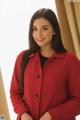 A woman in a red coat posing for a picture.