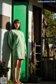 A woman standing in front of a green door.