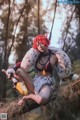 A woman with red hair sitting on a tree branch.