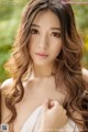 A woman with long brown hair posing for a picture.